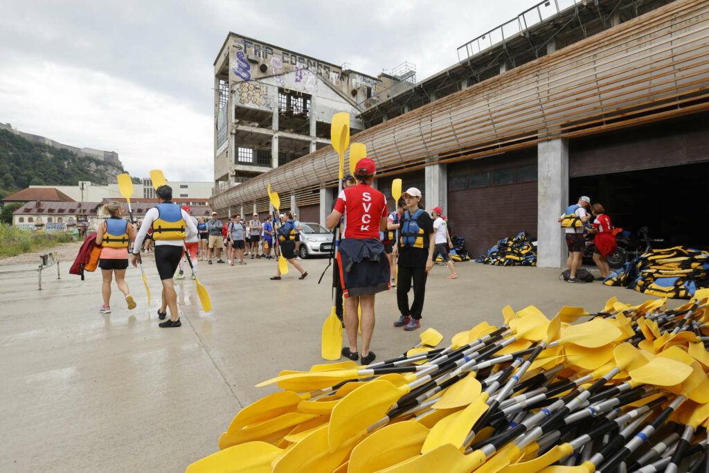 Kayakistes en gilet de sauvetage à côté d’une pile de pagaies hors de la base outdoor