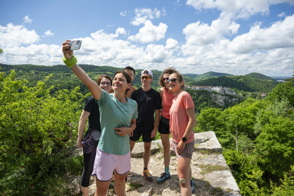 Coureurs de trail prenant un selfie au point de vue sur la Citadelle de Bregille