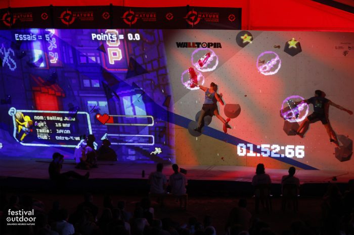 Participants escaladant un bloc d’escalade avec des projections lumineuses. Mapping avec nombre d'essais et points marqués